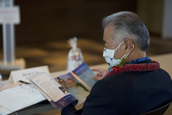 Govenor David Ige reads the UH Cancer Center's 50th anniversary publication